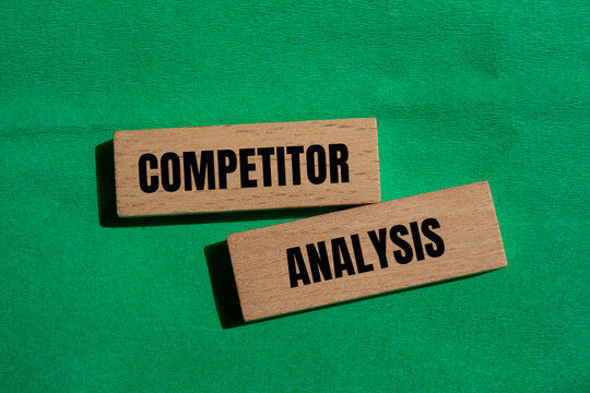 Competitor analysis message written on wooden blocks with green background. Conceptual competitor analysis symbol. Copy space.