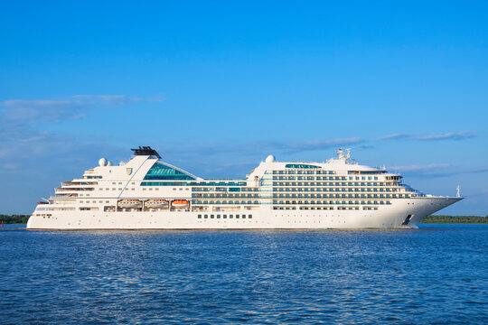 Stade, Germany &ndash; May 28, 2024: Cruise ship SEABOURN OVATION, owned by Seabourn Cruise line and registered in the Bahamas, on Elbe river heading to Hamburg under blue sky.