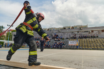 In a dynamic display of synchronized teamwork, firefighters hustle to carry, connect, and deploy...