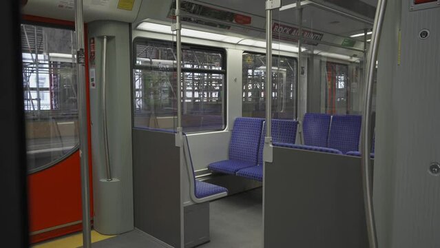 Innenansicht S-Bahn-Wagens ohne Personen in Berlin, Deutschland. S-bahn train coach interior inside with nobody in Berlin, Germany. Empty interior modern train Deutsche Bahn with blue checkered seats 