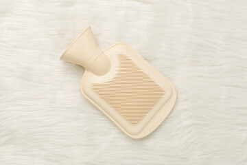 Rubber water warmer bag on textile background, top view
