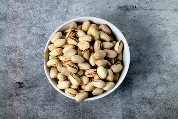 White bowl with unsalted pistachios seen from above