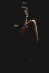 Naklejka premium Woman silhouette in dark. Beautiful Brunette Girl over black background