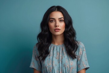 Fototapeta premium brunette girl on a blue background, portrait, emotions, copy space.