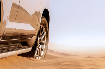 Close up of a golden car stuck in the sand in the Namib desert.