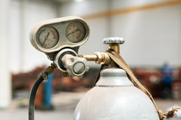 Close-up of dusty gauges of a steel cylinder gas tank filled with  argon, carbon dioxide or oxygen for welding in a factory