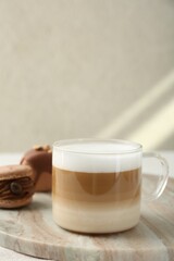 Aromatic coffee in cup and tasty macarons on table