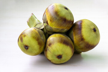 Asian palmyra palm (Borassus flabellifer) fruits isolated on white background. Fresh tropical fruit toddy palm.