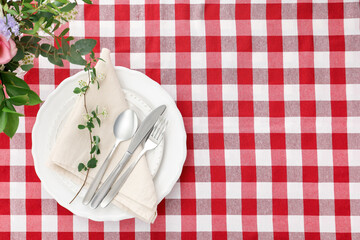 Stylish setting with cutlery, plates, napkin and floral decor on table, top view. Space for text