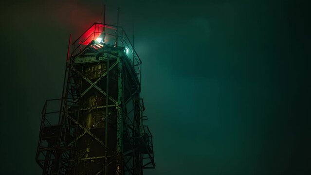 The towering structure illuminated at night a beacon of progress and industrialization in the midst of a dark landscape.