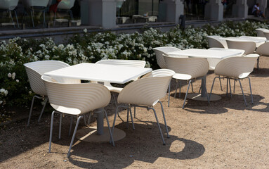 Outdoor street cafe tables ready for service. Modern Empty cafe terrace with table and chair, morning time. Food concept. Cafeteria, Outside Trattoria