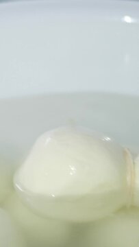 A wheel of Kacha Kavala cheese in a special brine in water exhibition preparation sale. seller takes it out
