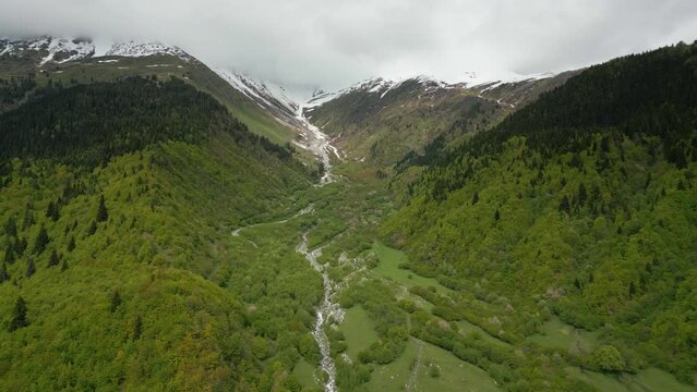 foot Mount Ushba in Caucasus, mountain stream, clouds over mountains,aerial view