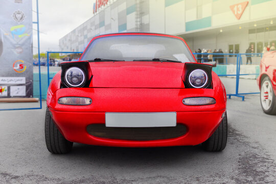 Russia, Novosibirsk, 25.05.2024 Midday, Red Mazda Miata MX-5 Roadster 1989, front view pop-up headlights