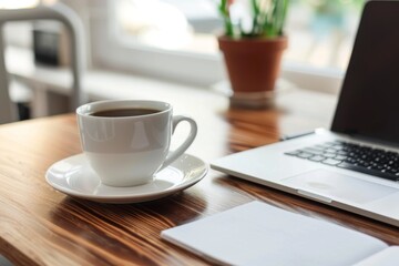 A clean and simple desk setup featuring a modern laptop, a notepad for jotting down ideas, and a steaming cup of coffee for focus and inspiration.