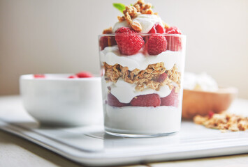 Food, nutrition and granola in glass for breakfast with fruit, morning energy and clean eating for lose weight. Berries, yogurt and dessert in container for brunch with balance and vitamin c benefits
