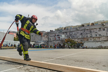 In a dynamic display of synchronized teamwork, firefighters hustle to carry, connect, and deploy...