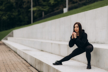 Side view of young adult girl in sportswear and sneakers shoes warming up, jogging on cardio workout, spending day on sport training outdoor in city