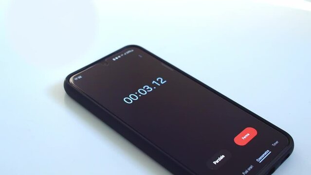 close up of starting a stopwatch on a smartphone, with black screen and white background