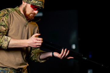 Fototapeta premium in a professional shooting range professional fighter assembles a NATO assault rifle