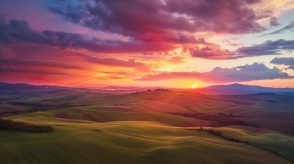 A breathtaking sunrise over rolling hills, with vibrant colors painting the sky and fluffy clouds scattered across the horizon.