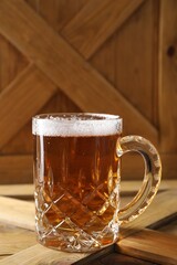 Mug with fresh beer on wooden crate