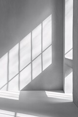 Geometric shadows from window light illuminating empty white room