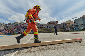 In a dynamic display of synchronized teamwork, firefighters hustle to carry, connect, and deploy...