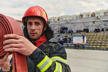 Fototapeta premium Professional Firefighter Cleaning Up Fire Hose After Extinguishing Blaze