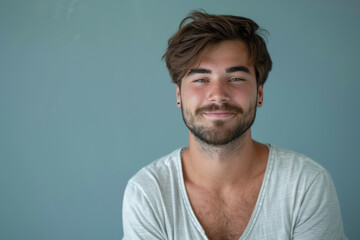 A close up portrait of a young man with a subtle smile