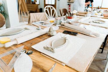 Ceramic workshop. Group of friends crafting a ceramic plate.