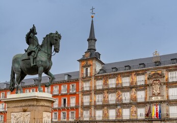 statue of Felipe II and the landmark buildings of the Plaza Mayor city square in downtown Madrid