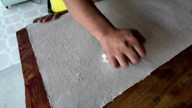 man hand uses a stone to smooth the paper. Thai craft 