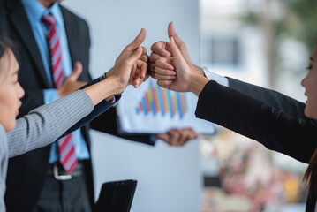 A group of business people giving thumbs up in a meeting.