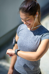 Happy woman, runner and watch with earphones in tracking performance or fitness in city. Female...