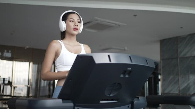 Pretty woman is exercising at high rise building fitness center.