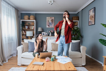 Young couple calling police to report domestic violence. Man and woman call 911 to report loud...