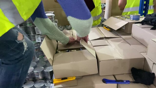 Volunteers collect humanitarian aid for war victims in Ukraine. Food kit for victims. Food packaging for the affected people. Humanitarian help. High quality 4k footage