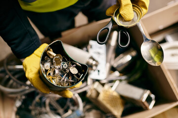A passionate young volunteer, dressed in yellow gloves, holds a pair of scissors while sorting waste as part of an eco-conscious initiative. - Powered by Adobe