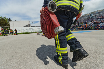 In a dynamic display of synchronized teamwork, firefighters hustle to carry, connect, and deploy...