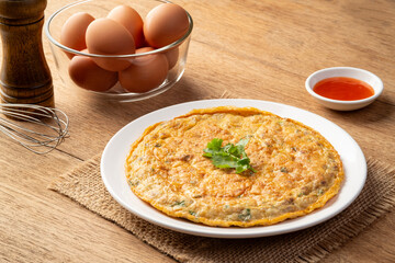 Thai style minced pork omelette with chili sauce in white plate