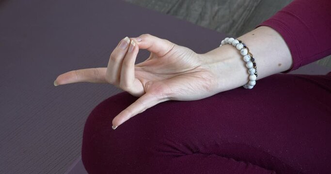 Woman doing apana mudra hand meditation gesture.