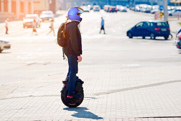 Man in protective helmet rides on monowheel. Man rides an electric unicycle on city street, showcasing modern mobility and eco-friendly transportation  for urban commuters and adventure enthusiasts © Tricky Shark