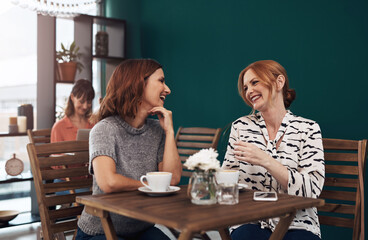 Laugh, women and together in coffee shop for connection, communication and friends in city. Joke, conversation and reunion in restaurant for gossip, discussion and chat with people in New York