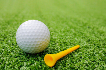 Golf balls and tees are placed on artificial grass.