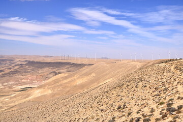 Fototapeta premium Wind turbine farm in remote arid desert environment generating renewable energy in Jordan, Middle East