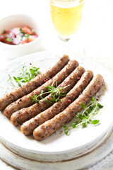 Roasted white sausages on bright wooden background. Copy spaces.