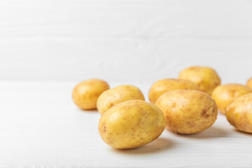 Young potatoes. Fresh potatoes  on a wooden background.Harvesting collection. organic, freshly dug potatoes. Agricultural background. Vegan. Vegetables.Place for text.Copy space