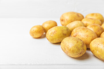 Young potatoes. Fresh potatoes  on a wooden background.Harvesting collection. organic, freshly dug potatoes. Agricultural background. Vegan. Vegetables.Place for text.Copy space