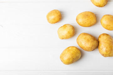 Young potatoes. Fresh potatoes  on a wooden background.Harvesting collection. organic, freshly dug potatoes. Agricultural background. Vegan. Vegetables.Place for text.Copy space